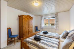 a bedroom with two beds and a wooden cabinet at Ferienwohnung Schönhals in Herbstein