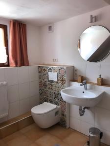a bathroom with a sink and a toilet and a mirror at Mein Ferienhaus Rosenbusch 2 in Kemmern