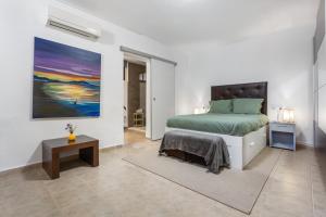 a bedroom with a bed and a painting on the wall at Tea-Rose Loft in Conil