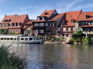 a group of buildings next to a river with a boat at Mein Ferienhaus Rosenbusch 2 in Kemmern