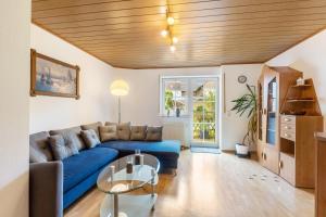 a living room with a blue couch and a table at Ferienwohnung Schönhals in Herbstein