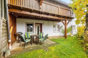 a patio with a table and chairs and a balcony at Ferienwohnung Schönhals in Herbstein