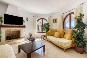 a living room with a yellow couch and a fireplace at Entre Caballos in Cumbre del Sol