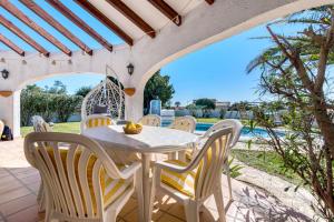 a patio with a table and chairs and a pool at Entre Caballos in Cumbre del Sol
