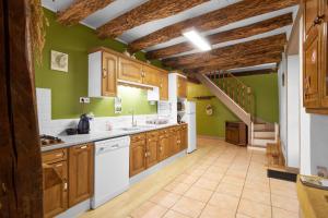 a kitchen with wooden cabinets and green walls at Domaine De Vic in Saint-Chamassy