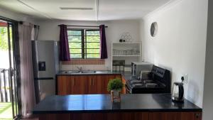 a kitchen with a black counter top and a refrigerator at Badumetsie cottage in Durban
