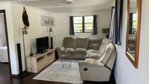 a living room with a couch and a television at Badumetsie cottage in Durban
