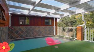 a patio with a swimming pool with a roof at Badumetsie cottage in Durban