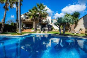 a swimming pool in front of a house with palm trees at Can Gual Inca in Inca