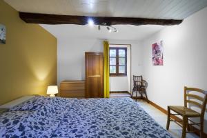 a bedroom with a blue bed and a chair at Domaine De Vic in Saint-Chamassy