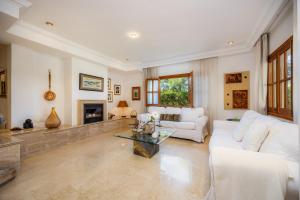 a living room with white furniture and a fireplace at Can Gual Inca in Inca
