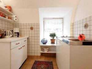 a kitchen with white cabinets and a sink and a window at Ferienwohnung Mengeler in Freiburg im Breisgau