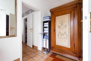 a hallway with a wooden door and a mirror at Ferienwohnung Mengeler in Freiburg im Breisgau