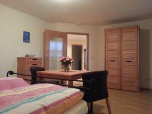 a bedroom with a table with a vase of flowers on it at Haus Schwärzler in Stiefenhofen +5 photos