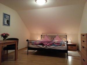 a bedroom with a bed with pink pillows on it at Haus Schwärzler in Stiefenhofen