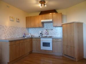 a kitchen with wooden cabinets and a white stove top oven at Haus Schwärzler in Stiefenhofen