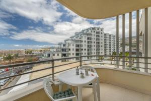 a balcony with a table and chairs and a building at Apartamento Sol Paraiso in Adeje