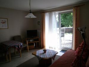 a living room with a couch and a sliding glass door at Gästehaus Fischerhäusle in Mitten