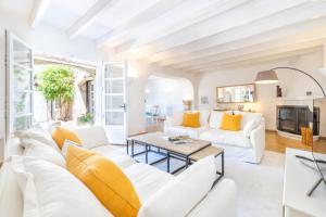 a living room with white furniture and yellow pillows at Can Verd Vall De Colonya in Pollença