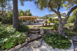 a garden with trees and a stone wall at Can Verd Vall De Colonya in Pollença
