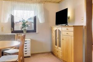 a living room with a tv on top of a dresser at Gemütliche Ferienhaus am Main in Gemünden