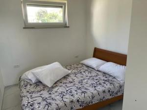 a small bedroom with a bed with a window at Počitniška hiška SEA HIDEAWAY in Ankaran