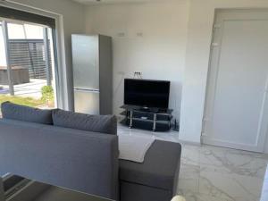 a living room with a couch and a flat screen tv at Počitniška hiška SEA HIDEAWAY in Ankaran