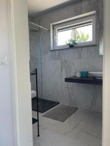 a bathroom with a shower and a sink and a window at Počitniška hiška SEA HIDEAWAY in Ankaran