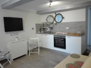 a kitchen with a stove and a tv in it at bilocale con il mare dentro in Bonassola