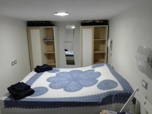 a bedroom with a bed with a blue and white blanket at bilocale con il mare dentro in Bonassola