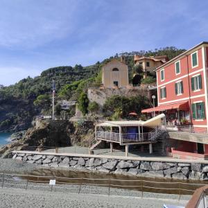 a building on the side of a beach next to the ocean at bilocale con il mare dentro in Bonassola