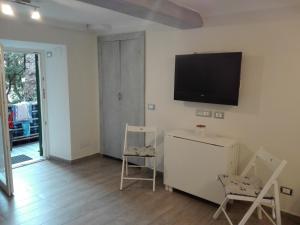 a living room with two chairs and a tv on the wall at bilocale con il mare dentro in Bonassola