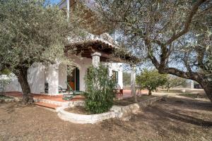 a white house with a tree in front of it at Villa Francesco P Terra in Orosei