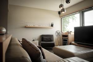 a living room with a couch and a chair at Gästehaus im Weingut am Stein in Würzburg
