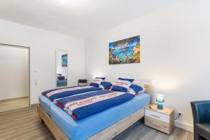 a bedroom with a bed with a blue comforter at Ferienwohnung Astrid in Sundern