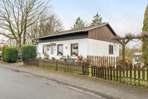 a small white house with a wooden fence at Ferienwohnung Astrid in Sundern