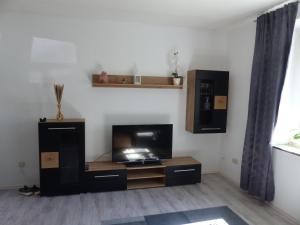 a living room with a flat screen tv on a stand at Ferienwohnung in Hof Saale in Hof