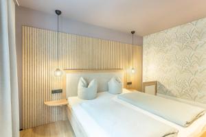 a bedroom with a bed with white sheets and pillows at Luisalle Top 2 in Auffach