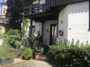 a white house with potted plants on the porch at Ferienwohnung Dora Brand in Arnsberg