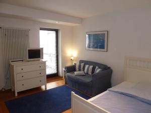 a bedroom with a bed and a chair and a television at Ferienwohnung Dora Brand in Arnsberg +6 photos