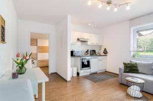 a white living room with a couch and a table at Ferienwohnung Inzigkofen in Inzigkofen