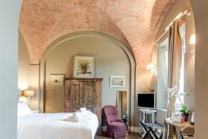 a bedroom with a white bed and a brick wall at Pretty Suite Firenze Fiesole in Florence