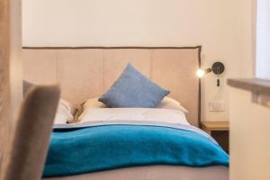 a bed with blue and white pillows on it at Apartment Annabel in Bolzano