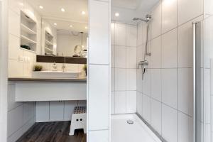 a white bathroom with a shower and a sink at Insel Hus in Fehmarn +20 photos