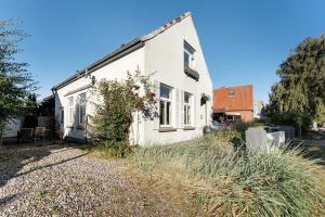 a white house with flowers on the side of it at Insel Hus in Fehmarn