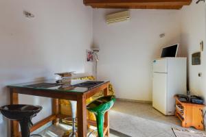 a kitchen with a table and a refrigerator at Samarighouse in Putzu Idu