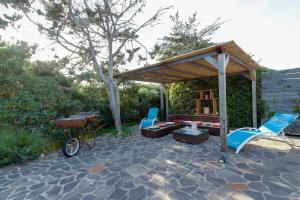 a patio with a picnic table and chairs and a bike at Samarighouse in Putzu Idu