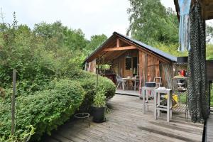 a small wooden cabin with a wooden deck at Cabane Myrtille in Arrien-en-Bethmale