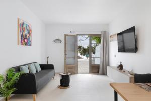 a living room with a black couch and a tv at Casita Lanzarote in Teguise