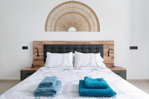 a bedroom with a bed with two blue towels on it at Casita Lanzarote in Teguise